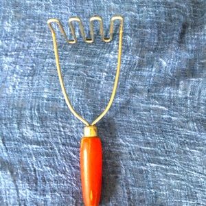 Vintage potato masher with red wooden handle